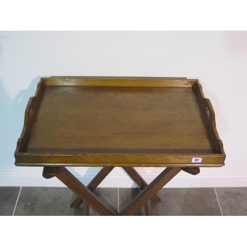 87 - An Edwardian/early 20th century oak butlers tray with X folding support - width 70cm x depth 47cm x ... 