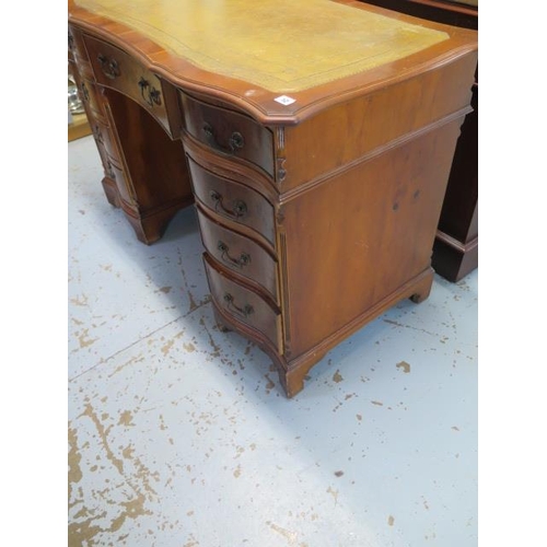 12 - A modern yew wood effect nine drawer twin pedestal desk with a shaped top and leather inset, 78cm ta... 