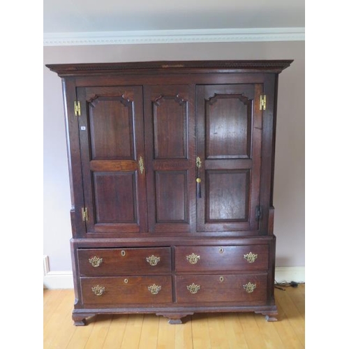 72 - An 18th century oak  cupboard on chest with two panelled doors above four drawers on shaped bracket ... 