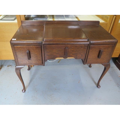 82 - An oak Art Deco style three drawer side table on shaped legs, 82cm tall x 107cm x 47cm