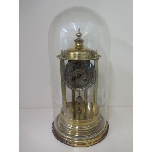 A brass portico clock under a glass dome striking on a bell in running order, some small dents to base but dome good, 45cm tall x 22cm wide