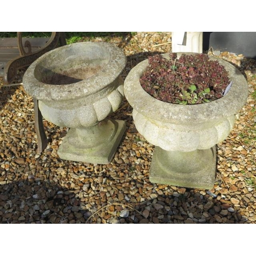 49A - A pair of stone effect concrete garden urns on stands, 40cm tall x 38cm diameter