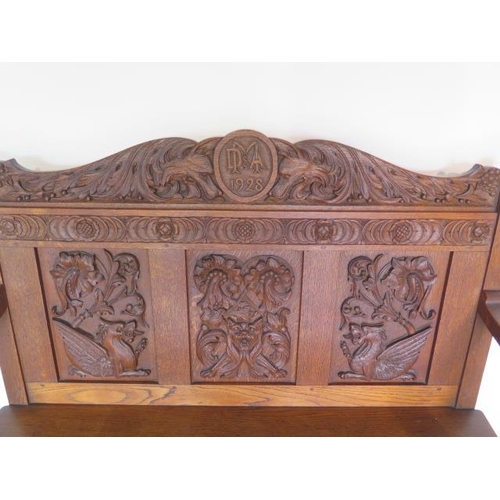 81 - A well carved oak bench hall settle, dated 1928, 106cm tall x 113cm x 55cm, in good condition with a... 