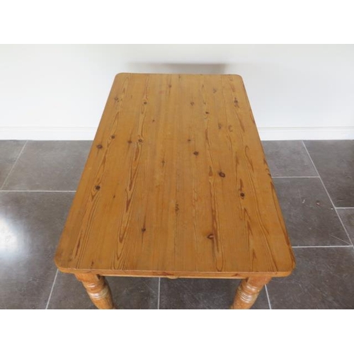 61 - A Victorian stripped pine kitchen table with an end drawer on turned legs with a 3cm thick top, 77cm... 