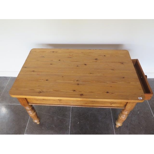 61 - A Victorian stripped pine kitchen table with an end drawer on turned legs with a 3cm thick top, 77cm... 