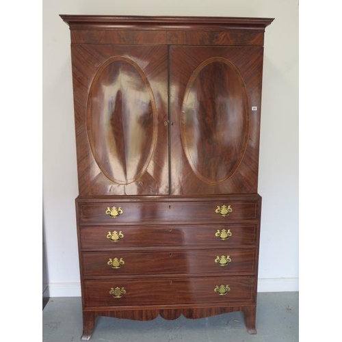 87 - A Georgian mahogany linen press with two door top enclosing a slide and a shelf above a four drawer ... 