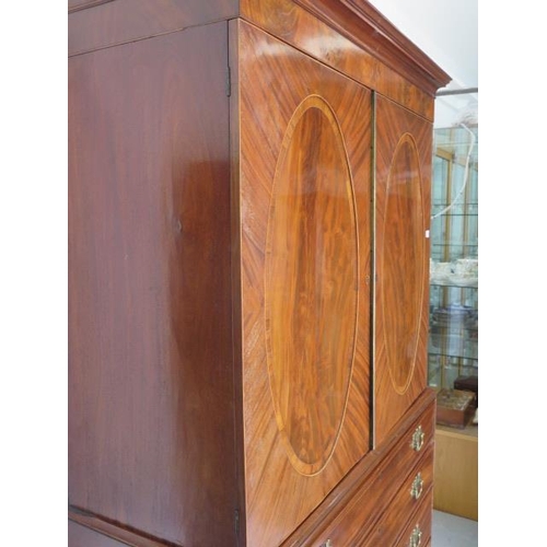 87 - A Georgian mahogany linen press with two door top enclosing a slide and a shelf above a four drawer ... 