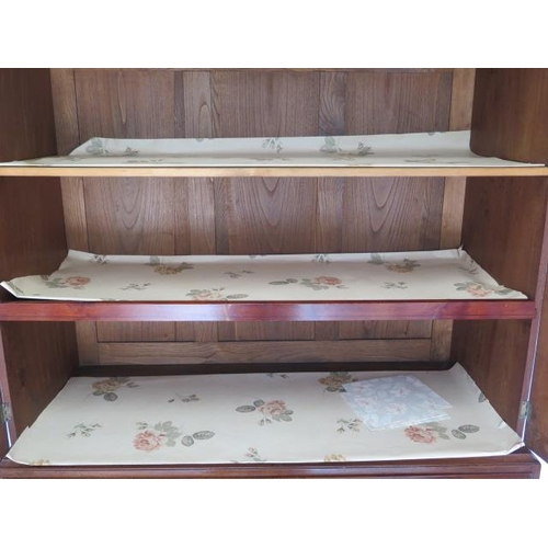 87 - A Georgian mahogany linen press with two door top enclosing a slide and a shelf above a four drawer ... 