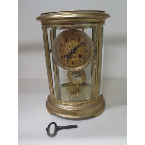 A French oval four glass mantle clock, 27.5cm tall x 19cm wide, striking on a single gong, in good working order, glass good