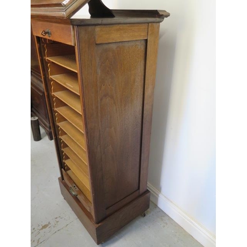 77 - A walnut tambour front cabinet with a rising top, 120cm tall x 50cm x 43cm