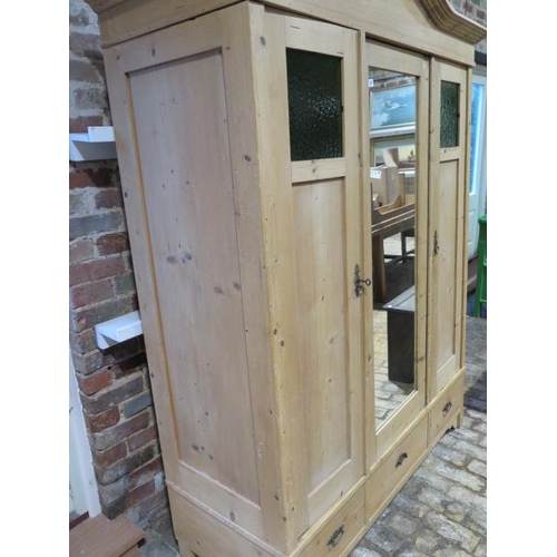 87 - A Continental stripped pine knock down three door wardrobe, disassembles for easy transport, 208cm t... 