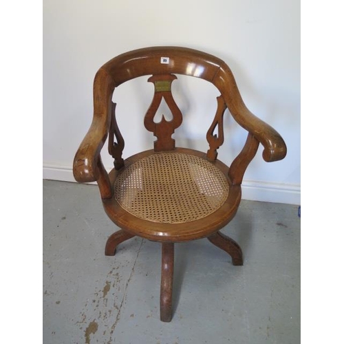 89 - A Victorian oak swivel desk chair with a cane seat having a brass plaque - This oak chair was made o... 