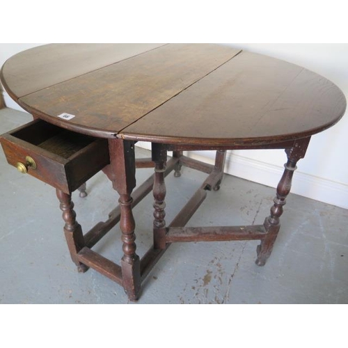 66 - An antique oak gateleg drop leaf table with a long drawer, 69cm tall x 85cm x 106cm extended