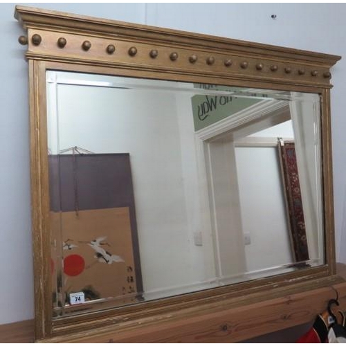 74 - A gilt overmantle mirror with bevel edge glass, 77cm tall x 100cm