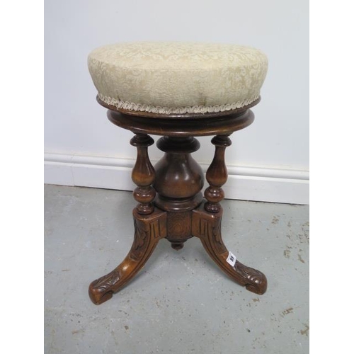 89 - A Victorian carved walnut revolving piano stool, recently reupholstered, in good condition