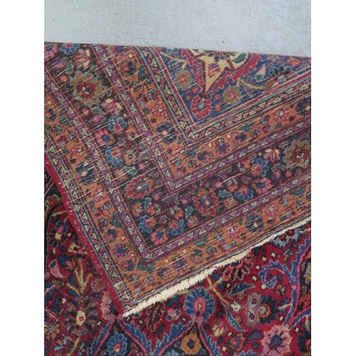 204 - A vintage woollen rug with a red field and a central medallion, 197cm x 129cm, wear mainly to fringe... 