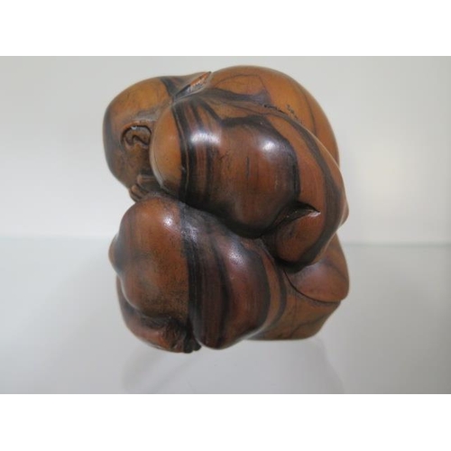 284 - A carved hardwood figure of a man rolled into a ball, 9cm tall, in good condition