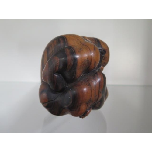 284 - A carved hardwood figure of a man rolled into a ball, 9cm tall, in good condition