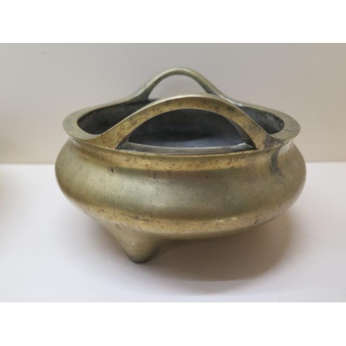 302 - A Chinese bronze censor with raised loop handles on three feet having Xuande 6 character mark to bas... 