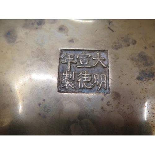 302 - A Chinese bronze censor with raised loop handles on three feet having Xuande 6 character mark to bas... 