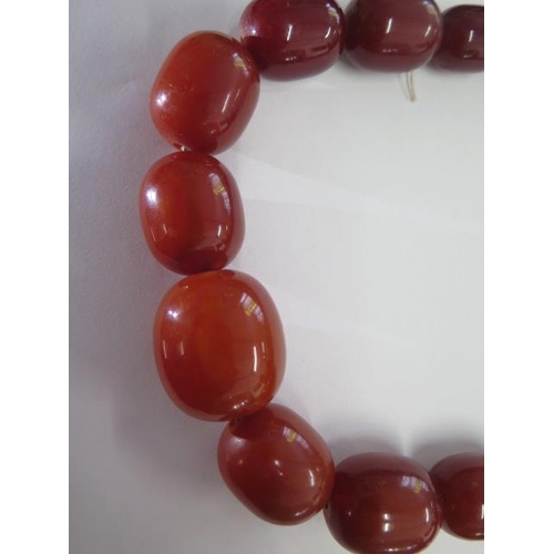 471 - An amber type necklace 67cm long, largest bead approx  3 cm x 2.5 cm, total weight approx 156 grams