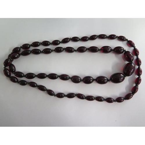 472 - A cherry amber similar type bead necklace, 104cm long, largest bead approx 2.5 cm x 1.5 cm, approx 8... 