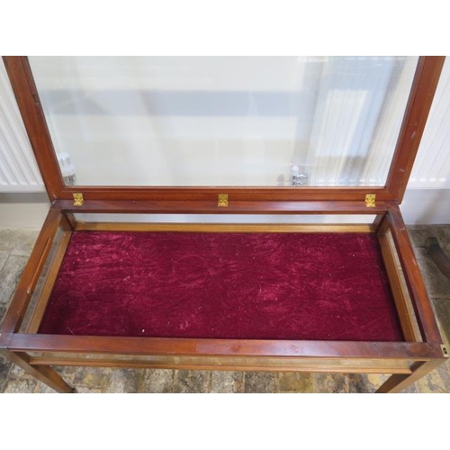 61 - A mahogany bijouterie display table on square tapering legs with bevel edge glass to the hinged top,... 