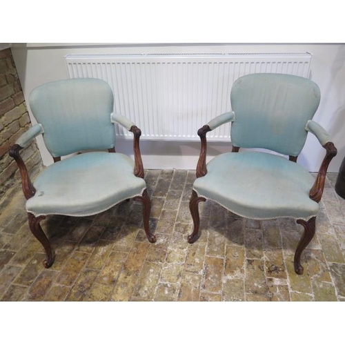 66 - A a pair of carved open armchairs with scroll arms on shaped carved front legs with horsehair stuffi... 