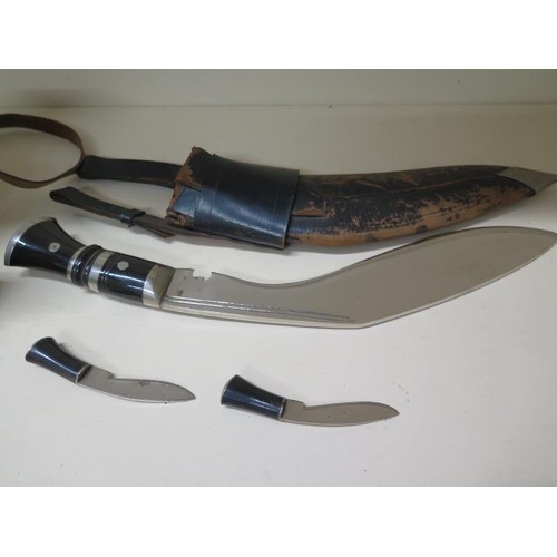 907 - A Kukri with scabbard and small knives, blade length 31cm, some pitting to blades and wear to scabba... 