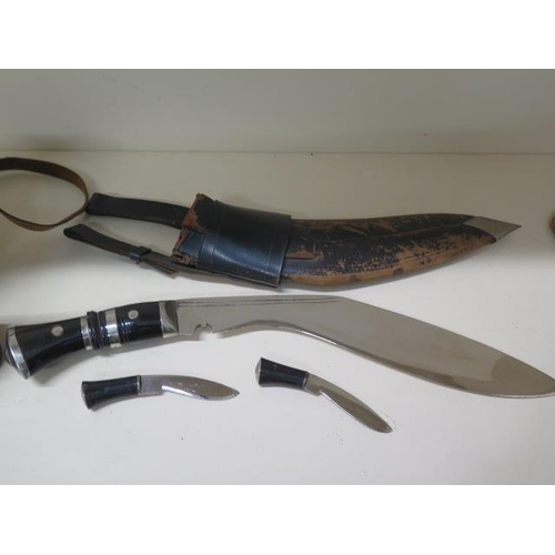 907 - A Kukri with scabbard and small knives, blade length 31cm, some pitting to blades and wear to scabba... 