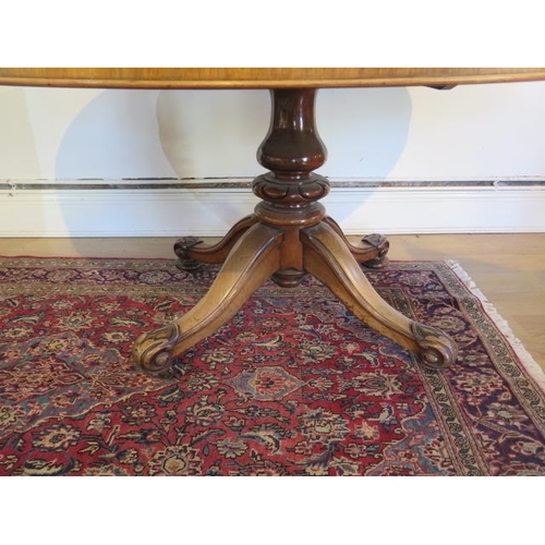 95 - A Victorian burr walnut tilt top oval breakfast / dining table, on turned and carved column and quat... 