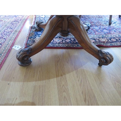 95 - A Victorian burr walnut tilt top oval breakfast / dining table, on turned and carved column and quat... 