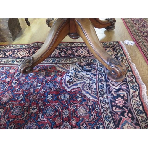 95 - A Victorian burr walnut tilt top oval breakfast / dining table, on turned and carved column and quat... 