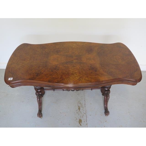 79 - A good Victorian burr walnut stretcher table with a shaped top on twin carved supports united by a c... 