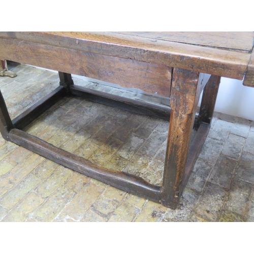 93 - An 18th century oak dining table with a 5cm thick top on square chamfered legs united by all round s... 