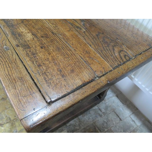 93 - An 18th century oak dining table with a 5cm thick top on square chamfered legs united by all round s... 