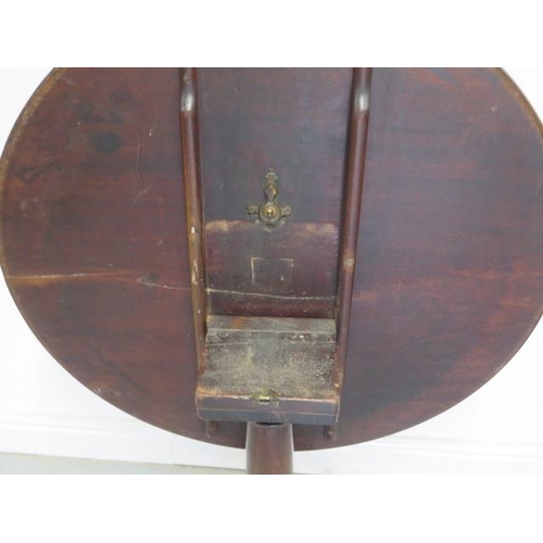 95 - A Georgian mahogany tilt top side table with a single piece 80cm top on a tapering gun barrel column... 