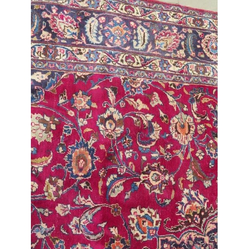 205 - A large hand knotted Persian woollen rug, some patches of wear consistent with use, 397cm x 292cm