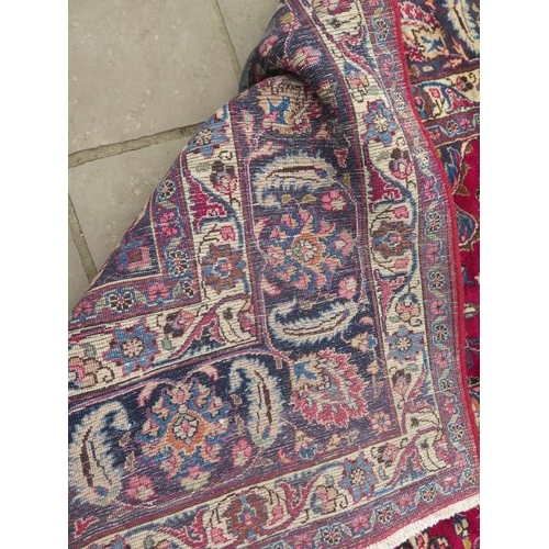205 - A large hand knotted Persian woollen rug, some patches of wear consistent with use, 397cm x 292cm
