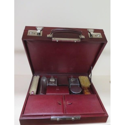 317 - A vintage red leather fitted travel case with bottles, brushes and other fittings, 14cm x 37cm x 30c... 