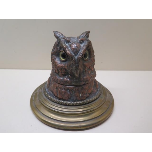 327 - A copper and brass owls head desk inkwell, 13cm tall, with original glass insert, small chips to ins... 