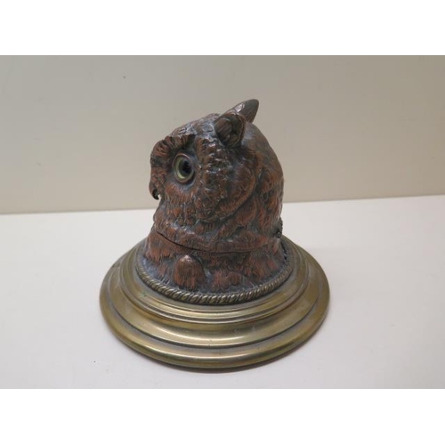 327 - A copper and brass owls head desk inkwell, 13cm tall, with original glass insert, small chips to ins... 