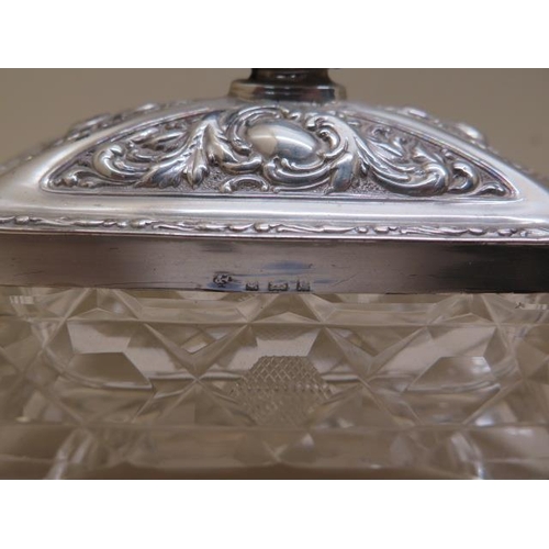 425 - A heavy cut glass oblong trinket box on 4 feet and star cut base with decorated silver cover, Birmin... 