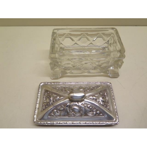 425 - A heavy cut glass oblong trinket box on 4 feet and star cut base with decorated silver cover, Birmin... 