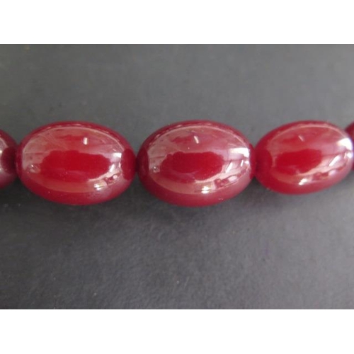 463 - A string of cherry amber type beads, largest 3cm x 2cm, 82cm long, also with a coloured pearl neckla... 