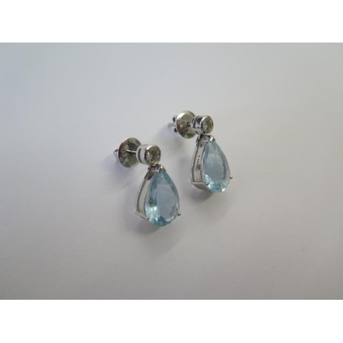 492 - A pair of 18ct 750 white gold diamond and possibly blue topaz tear drop earrings, 18mm tall, both in... 