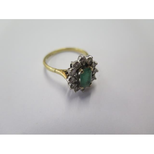 503 - A hallmarked 18ct yellow gold emerald and diamond cluster ring, the emerald approx 8mm x 5mm x 3mm, ... 