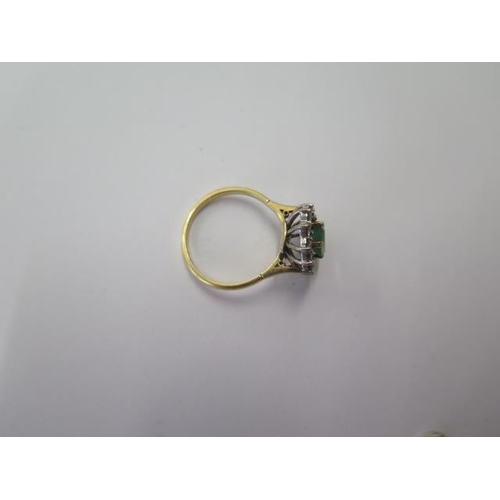 503 - A hallmarked 18ct yellow gold emerald and diamond cluster ring, the emerald approx 8mm x 5mm x 3mm, ... 