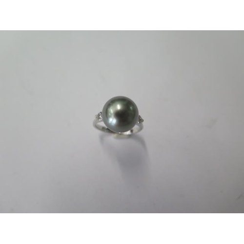 512 - An 18ct white gold black pearl and diamond ring, pearl approx 10mm, ring size J, approx 4.3 grams, i... 