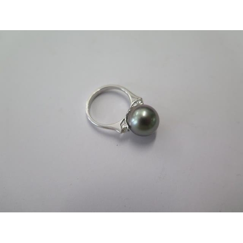 512 - An 18ct white gold black pearl and diamond ring, pearl approx 10mm, ring size J, approx 4.3 grams, i... 